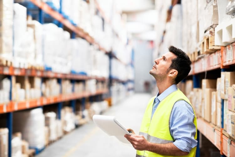A young man doing stock take in a storehouse